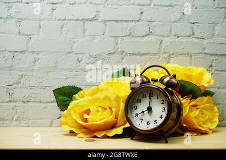 Sveglia con decorazioni floreali su sfondo bianco murale Foto Stock