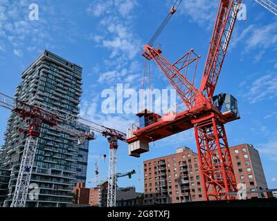 cantiere con gru multiple per la costruzione di un nuovo alto edificio di appartamenti Foto Stock