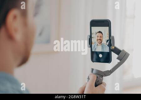 Bel giovane uomo vlogging o registrare video su smartphone Foto Stock