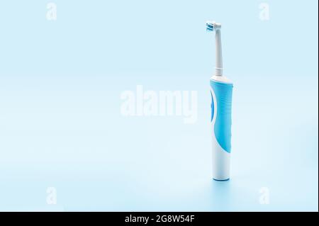moderno spazzolino elettrico su sfondo blu. Strumenti di cura dentale. Concetto di buona igiene della bocca. Concetto di cura orale professionale e denti sani b Foto Stock