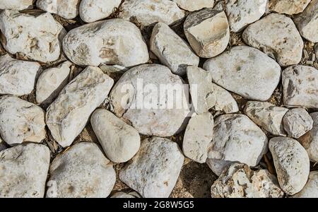 Sfondo del muro di pietra del castello fatto di pietre di forme e dimensioni e texture diverse Foto Stock