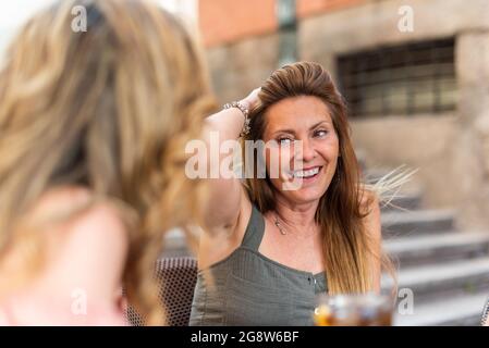 Donna matura in un caffè che beve con i suoi amici Foto Stock