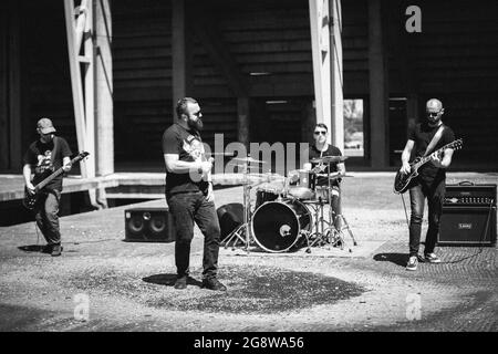 DISTRETTO DI BRCKO, BOSNIA-ERZEGOVINA - 10 luglio 2020: Una foto in scala di grigi di giovani musicisti in un concerto rock all'aperto Foto Stock