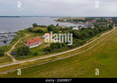 Hiddensee, Germania. 25 Giugno 2021. Vista sul porto di Vitte. Il comune di Seebad Hiddensee sta attualmente progettando l'espansione del porto. Tra le altre cose, si costruisce un nuovo porto turistico con 135 posti barca per imbarcazioni da diporto. Il progetto è controverso. Un'iniziativa dei cittadini sta cercando di impedire il risviluppo del porto. (Foto aerea con drone) Credit: Stephan Schulz/dpa-Zentralbild/ZB/dpa/Alamy Live News Foto Stock
