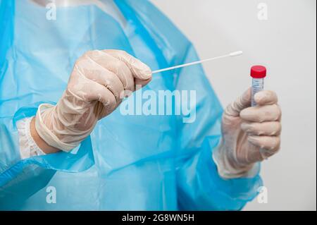 Un operatore medico che contiene un kit di raccolta dei campioni con tampone. Foto Stock