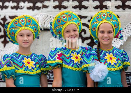I bambini kirghisi si vestono per esibirsi durante il giorno dell'Indipendenza, festa nazionale, in Piazza Ala Too, Bishkek, Kirghizistan Foto Stock