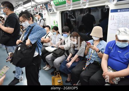 Le persone che indossano maschere per il viso come misura preventiva usano un tram a Pechino. Giovedì 22 luglio 2021, un alto funzionario sanitario cinese ha dichiarato che la Cina non può accettare il piano dell'Organizzazione mondiale della sanità per la seconda fase di uno studio sulle origini del COVID-19. Foto Stock