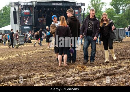 Persone in un festival di musica rock all'aperto fangoso Foto Stock