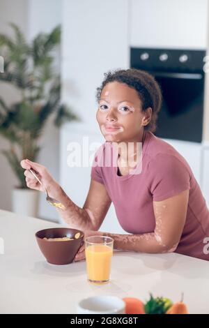 Giovane donna dalla pelle scura che ha fatto colazione a casa Foto Stock
