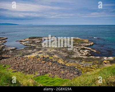 Piattaforma di taglio delle onde - rocce costiere erose dall'azione delle onde - vicino a Portrush sulla costa di Antrim Causeway nell'Irlanda del Nord, Regno Unito. Preso su un sole Foto Stock