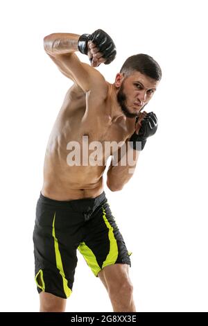 Punzonatura. Un pugile MMA maschile professionista che pratica isolato su sfondo bianco studio. Combatti con un atleta caucasico muscolare. Foto Stock