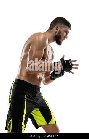 Vista laterale. Primo piano ritratto di atleta caucasico, professionista maschile MMA boxer isolato su sfondo bianco studio. Sport, competizione e umana Foto Stock