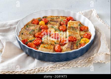 Merluzzo al forno guarnito con pomodori ciliegini e timo Foto Stock