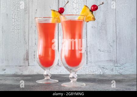 Due bicchieri di Singapore Sling su sfondo di legno Foto Stock