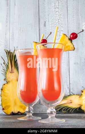 Due bicchieri di Singapore Sling su sfondo di legno Foto Stock