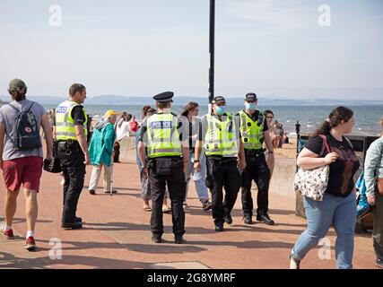 Portobello, Edimburgo, Scozia, tempo britannico. 23 luglio 2021. Sole ma ventilato nel pomeriggio con una temperatura di 20 gradi centigradi al mare dopo una mattina nuvolosa nella capitale scozzese. Abbastanza occupato sulla spiaggia di sabbia ma una buona quantità di presenza della polizia, ma poco per loro a fare tranne la pattuglia nel tardo pomeriggio. Credit: Arch Whire/Alamy Live News. Foto Stock