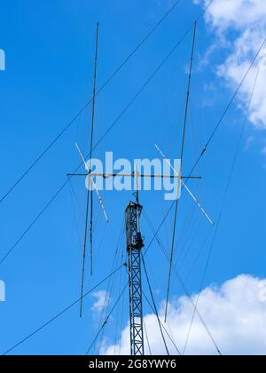 Antenna radio HAM alta contro il cielo nuvoloso bluu Foto Stock