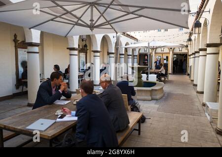 Le persone in tute cenano e si incontrano all'aperto presso la Blue Bottle Coffee Shop di Silicon Valley, Palo Alto, California, parte di un riutilizzo adattivo che ha trasformato l'ex Teatro Varsity in un caffè di lusso e HanaHouse, spazio di lavoro congiunto, il 14 novembre 2017. (Foto di Smith Collection/Gado/Sipa USA) Foto Stock