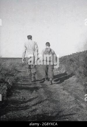Anni '50, storico, due maschi adulti, entrambi indossando pantaloni di lana e uno con un canvas rucksavk sulla schiena, a piedi su un sentiero vicino Beachy Head, sul South Downs, East Sussex, Inghilterra, Regno Unito. Beachy Head è la più alta scogliera di mare di gesso in Gran Bretagna e la sua zona circostante, un luogo famoso per le passeggiate di piacere, con magnifiche viste sulla Manica. Un'area di straordinaria bellezza naturale, nel 1929, un atto del Parlamento, ha permesso l'acquisto della terra per proteggerne e salvaguardarne l'uso per le generazioni future. Foto Stock