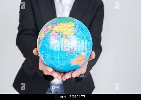 Primo piano donna che tiene una mappa vintage della mappa mondiale del globo in mano, concetto di business Foto Stock