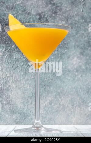 Bicchiere di Apricot Mango cocktail guarnito con fetta di mango fresco Foto Stock