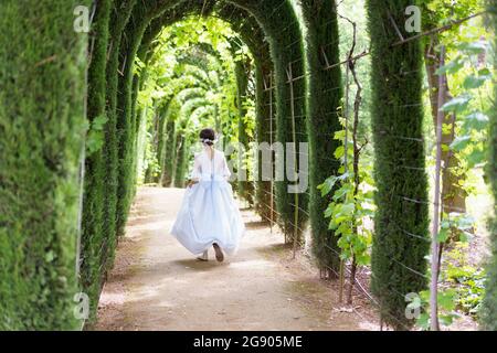 Ragazza che cammina in giardino il giorno della comunione Foto Stock