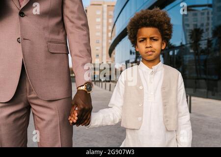 Uomo che tiene la mano del ragazzo mentre si alza sul sentiero Foto Stock