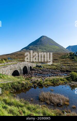 Regno Unito, Scozia, Sligachan, Ponte Vecchio di Sligachan con montagna sullo sfondo Foto Stock