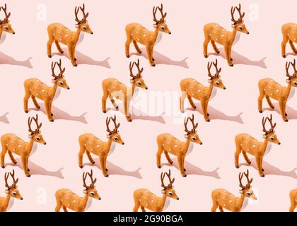 Modello di figurine di renna in piedi su sfondo rosa Foto Stock