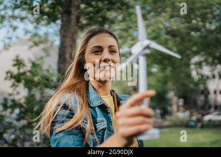 Giovane donna che guarda il modello di turbina eolica Foto Stock
