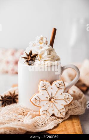 Biscotto di Natale a forma di fiocco di neve e tazza di chai caldo frothy Foto Stock