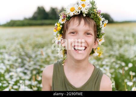 Ragazzo con fior di tiara sorridente in campo Foto Stock