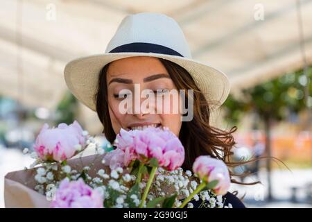 Donna che guarda il bouquet di fiori di peonie Foto Stock
