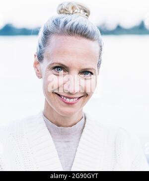 Donna matura bionda sorridente con rughe Foto Stock