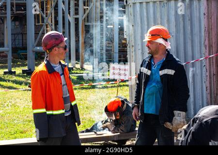 I saldatori ucraini discutono di questioni di lavoro sul terreno di costruzione della raffineria a gas Shebelinka 20,000 b/d nella regione di Kharkov, nell'Ucraina orientale. Foto Stock