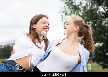 Buone amiche che si guardano mentre si godono in natura Foto Stock