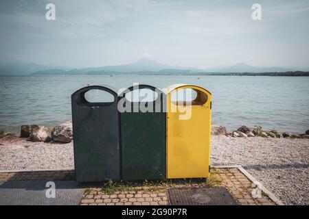 Tre diversi bidoni per la raccolta dei rifiuti per separare la raccolta dei rifiuti sulla riva del lago di Garda Foto Stock