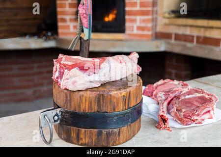 Carne cruda su un ponte, un coltello bloccato nella carne. Carne fresca su un tagliere. Primo piano. Foto Stock