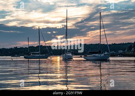 Splendido tramonto a Boothbay Harbour nel Maine. Barche a vela ormeggiate nel porto per la notte. Foto Stock