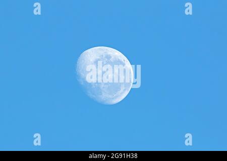 Vista della luna in un cielo blu chiaro e senza nuvole Foto Stock