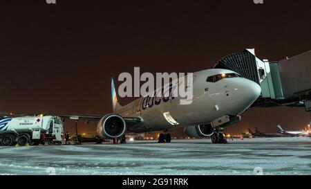 Tempo di imbarco sull'aereo FlyDubai e di carico dei bagagli durante la notte invernale Foto Stock