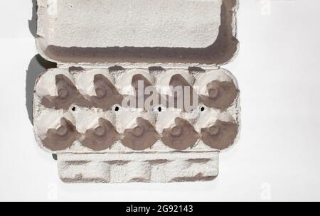 Scatola di uovo grigia senza uova su sfondo bianco. Foto Stock