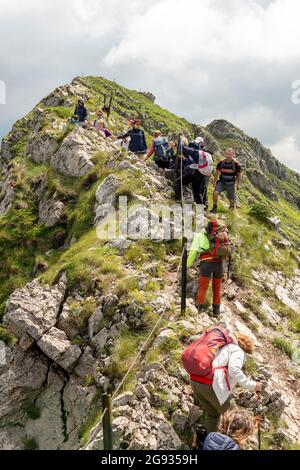 Gruppo di escursionisti che attraversano il picco di Kozya Stena o il muro di camoscio sulla strada pedonale transitoria europea percorso e-3, Balcani centrali, Bulgaria Foto Stock