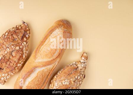 Pane fresco, croissant e baguette su sfondo giallo chiaro. Shopping supermercato alimentare e concetto di panetteria. Foto Stock