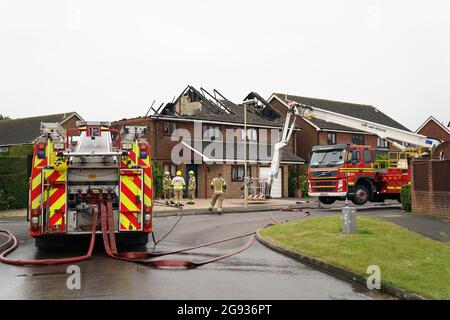 Vigili del fuoco dell'Hampshire e dell'Isola di Wight Fire and Rescue Service sulla scena di Mercia Avenue ad Andover, dove una donna di 70 anni è scappata senza subire danni dopo un fulmine ha gravemente danneggiato due case. Data immagine: Sabato 24 luglio 2021. Foto Stock