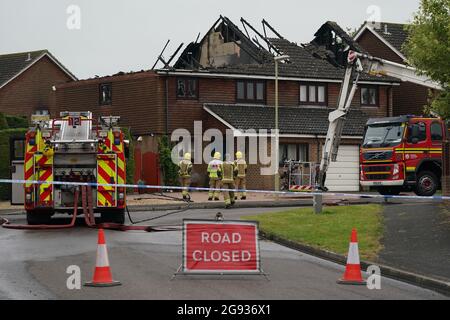 Vigili del fuoco dell'Hampshire e dell'Isola di Wight Fire and Rescue Service sulla scena di Mercia Avenue ad Andover, dove una donna di 70 anni è scappata senza subire danni dopo un fulmine ha gravemente danneggiato due case. Data immagine: Sabato 24 luglio 2021. Foto Stock