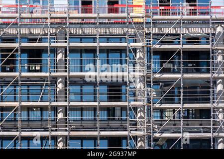 Impalcature senza lavoratori poste sulla facciata di un edificio d'ufficio. Concetti di costruzione e ristrutturazione immobiliare Foto Stock