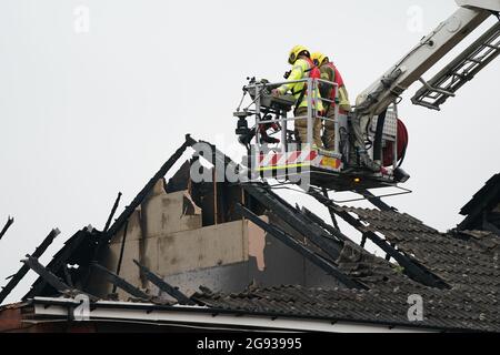 Vigili del fuoco dell'Hampshire e dell'Isola di Wight Fire and Rescue Service sulla scena di Mercia Avenue ad Andover, dove una donna di 70 anni è scappata senza subire danni dopo un fulmine ha gravemente danneggiato due case. Data immagine: Sabato 24 luglio 2021. Foto Stock