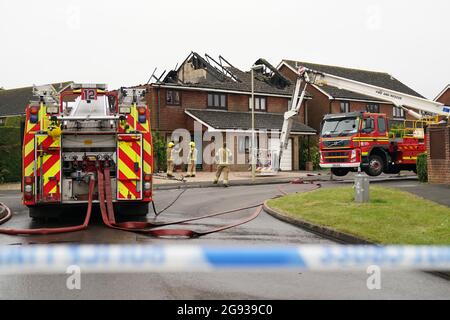 Vigili del fuoco dell'Hampshire e dell'Isola di Wight Fire and Rescue Service sulla scena di Mercia Avenue ad Andover, dove una donna di 70 anni è scappata senza subire danni dopo un fulmine ha gravemente danneggiato due case. Data immagine: Sabato 24 luglio 2021. Foto Stock