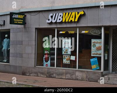 Vista della filiale del ristorante fast food Subway (panini sottomarini) nel centro di Esslingen con logo di colore bianco e giallo sopra la vetrina. Foto Stock